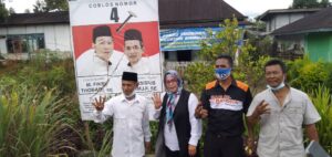 Calon Wakil Bupati Rejang Lebong, Tarsisius Samuji, S. Pd didampingi istri beserta Tim FIS, saat berpose depan Baliho rusak yang telah dijahit oleh Mbah Jenggot